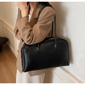 Dettaglio della borsa tote in pelle nera a grana litchi con spalline robuste