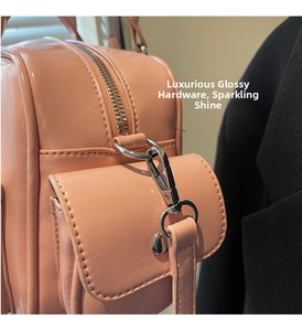 Nahaufnahme der rosa Lackleder-Handtasche mit silbernen Metallbeschlägen und Reißverschluss