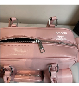 Detailansicht des silbernen Reißverschlusses und der Lederstruktur einer rosa Handtasche