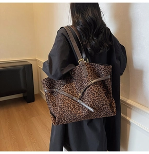 Detail of leopard print suede tote with adjustable brown leather strap and metal buckle