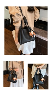Black leather bucket bag detail view with cute horse charm, stylish women handbag for autumn.