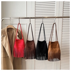 Fila de bolsos bombonera de ante con flecos en rojo, marrón, negro y caramelo en rack