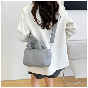Detail of grey padded puffer tote bag showing soft quilted nylon texture and shoulder strap