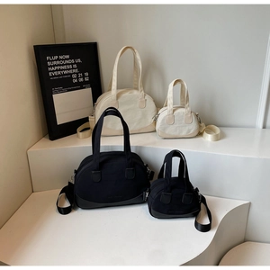Collection of black and white canvas tote bags in various sizes on display stands