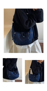Detailed close-up of dark blue denim crescent bag with drawstring pocket and silver zipper