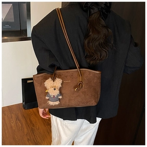 Brown suede tote bag with leather handle and cute teddy bear charm on shoulder