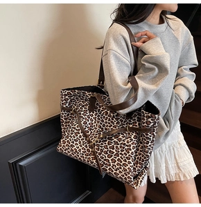 Detailed side view of large leopard print tote bag with brown faux leather straps