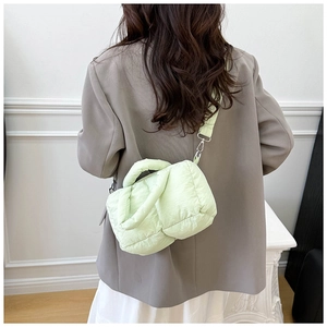 Detail of mint green quilted puffer tote bag shown on a model for scale and fit