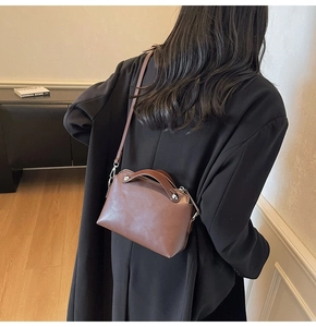 Braune Leder-Boston-Tasche im 45-Grad-Winkel getragen von einem Modell im Alltag
