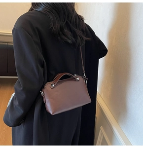 Detaillierte Rückansicht einer dunkelbraunen Mini Boston Bag mit silbernen Nieten