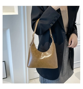 Detail of vintage brown hobo bag with oily leather texture and adjustable shoulder strap