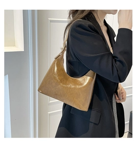 Brown vintage glossy leather hobo bag styled with a black blazer for a commute look