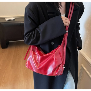 Close-up of a soft red glossy tote bag styled with a black blazer for a chic urban look