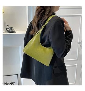 Side view of a glossy grass green hobo shoulder bag styled with a black blazer