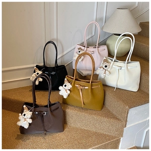 Sacs cabas en cuir grainé de cinq couleurs avec de petits oursons en peluche sur l'escalier