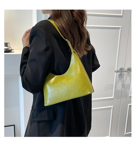 Chic lime green patent leather baguette bag styled with a sleek black blazer
