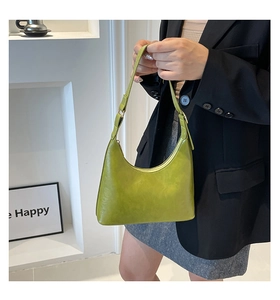 Close-up of a glossy avocado green hobo bag featuring a sleek crescent shape and PU leather