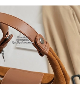 Détail macro du cuir et daim caramel avec des garnitures métalliques argentées d'un sac