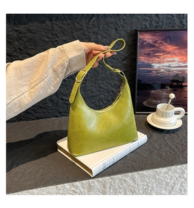 Detail of avocado green hobo bag with adjustable shoulder strap and gold hardware