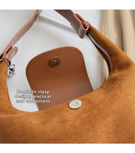 Détail du sac à main en daim marron chaud avec fermoir magnétique et fermeture éclair