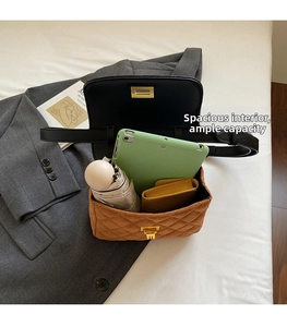 Spacious interior of tan quilted crossbody bag holding a tablet, umbrella, and wallet