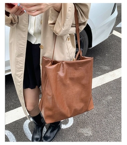 Brown oil wax leather tote bag shown on a model during daily outdoor commuting