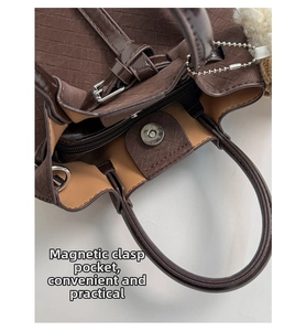 Detail view of brown woven leather bucket bag featuring a magnetic snap and zip pocket