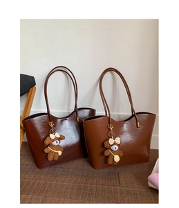 Vue détaillée de deux grands sacs fourre-tout en similicuir marron avec pendentifs ours