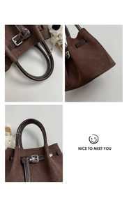 Close-up of woven texture and silver buckle details on a dark brown bucket bag