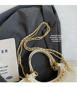 Close-up of quilted tote bag with metal chain strap and luxury gold hardware detail