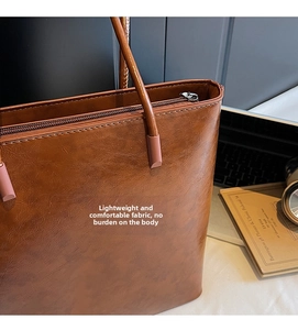 Detail of dark brown leather tote with smooth zipper and vintage oil wax texture finish
