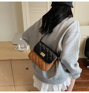Rear view of model wearing a two-tone quilted shoulder bag with gold square twist lock