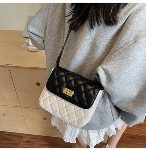 Detail of vintage quilted crossbody bag featuring contrast colors and gold metal lock