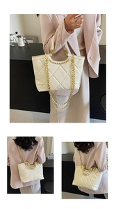 Detail of white quilted tote bag with gold chain strap and elegant diamond stitching