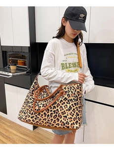 Macro detail of leopard print tote travel bag with brown leather trim and silver metal hardware