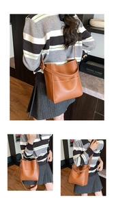 Detail of caramel brown leather bucket bag with contrast white stitching and shoulder strap