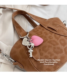 Detail of leopard print handbag with pink heart and silver key charms attached