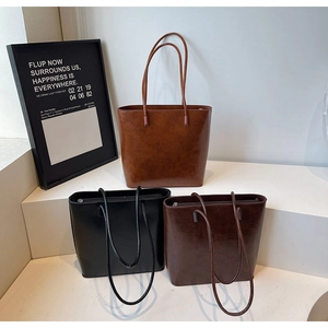 Three minimalist matte leather tote bags in brown, black, and coffee on display