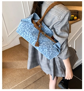 Dettaglio della borsa tote in denim leopardato blu con tracolle in pelle scamosciata