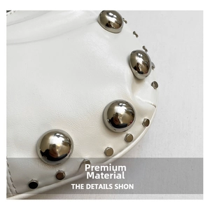 Detailed close-up of white leather bag with silver metallic rivets and punk style texture