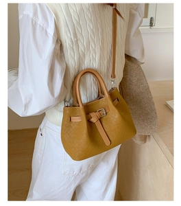 Retro woven bucket shoulder bag for women, elegant commuter handbag with top handle and strap.