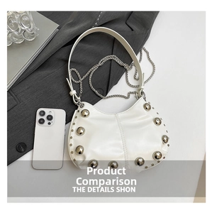 Detailed shot of white hobo bag with large silver studs and metallic chain strap