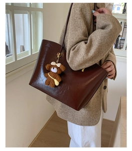 Grand sac cabas marron foncé en cuir brillant avec un joli pendentif en forme d'ours brun