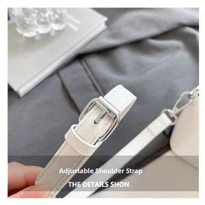 Detailed macro view of white pebble leather adjustable shoulder strap with silver buckle