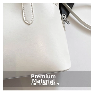 Close-up of white shell bag with lychee grain leather texture and metallic strap hardware