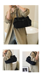 Detail of black leopard pattern tote bag with leather handles and metal buckle closure
