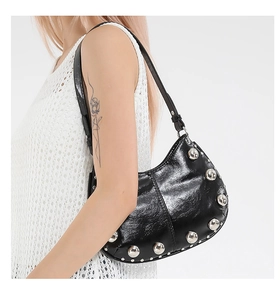 Detail of black semi-circle shoulder bag with silver studs and smooth leather texture