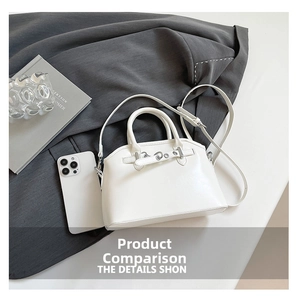 Close-up of white shell bag with metallic ring detail next to a smartphone