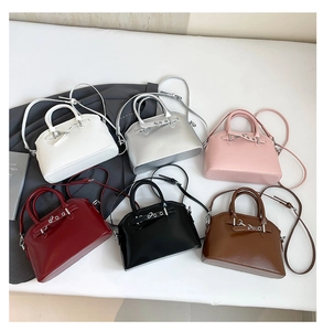 Flat lay of stylish shell-shaped handbags in six colors with glossy finish and top handles
