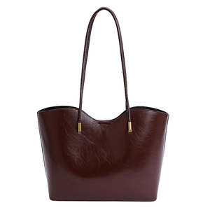 Grand sac cabas bordeaux en cuir huilé avec longues anses et finitions dorées chic.